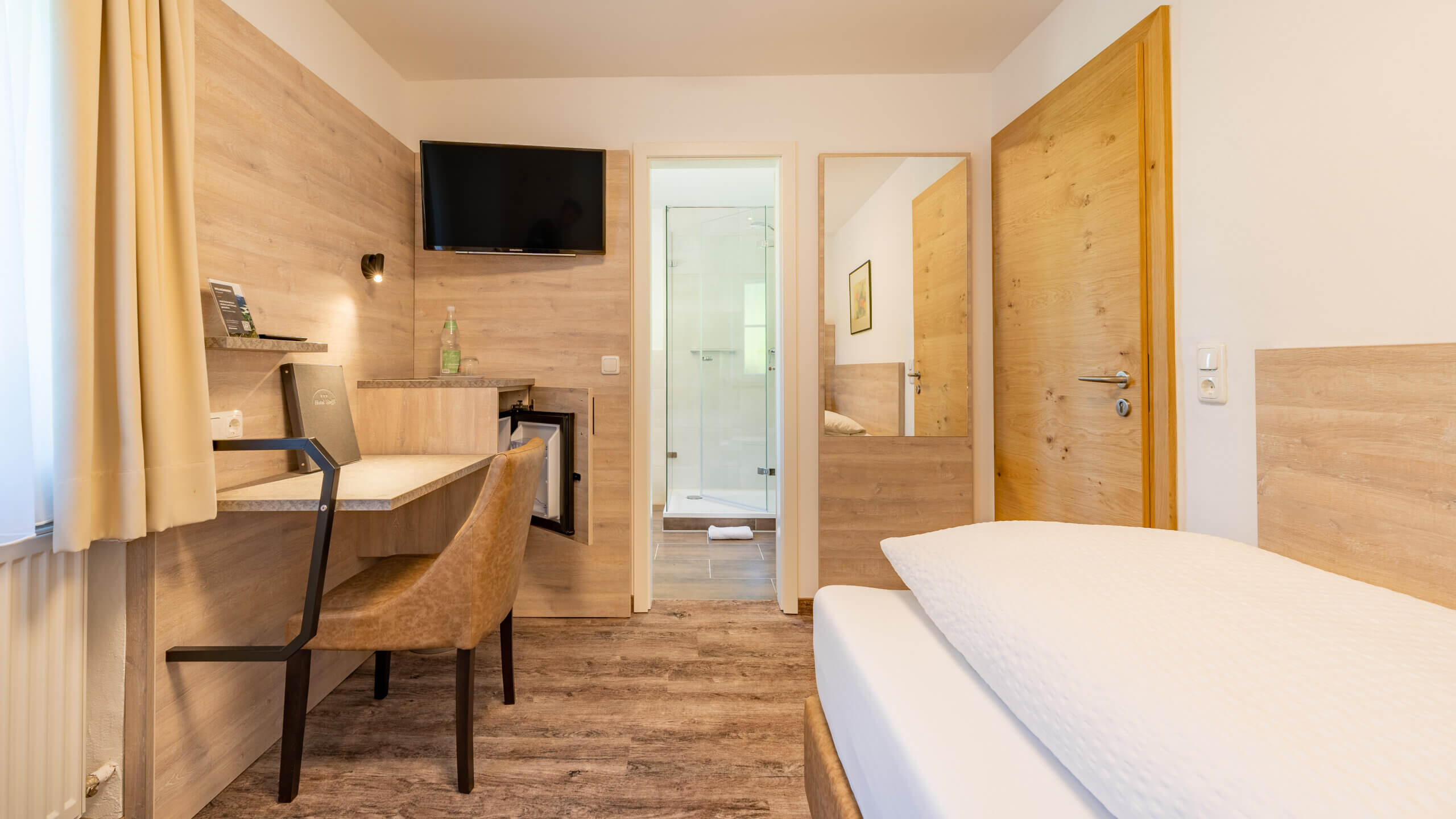 <p>Praktischer Blick auf Bett, TV und Badezimmer in einem</p>